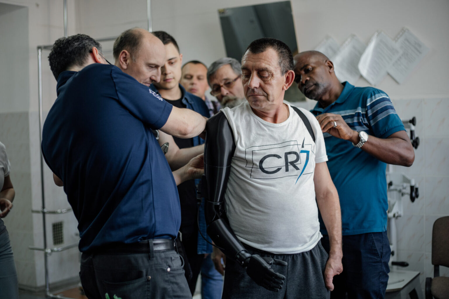 A clinician fits a custom 3D-printed prosthetic arm for a patient at a Victoria Hand Project site.